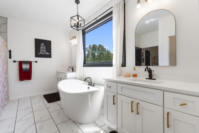 bathroom with a bathtub, vanity, and a notable chandelier