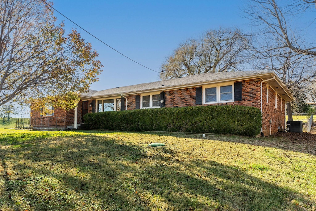 ranch-style home with central AC and a front lawn