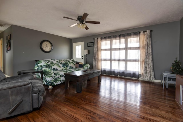 living room with ceiling fan, dark hardwood / wood-style flooring, and a textured ceiling