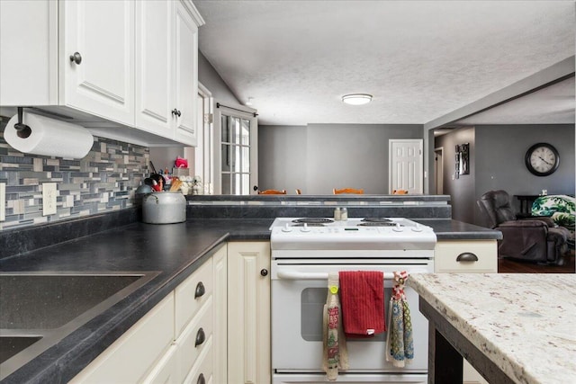 kitchen featuring electric stove, white cabinetry, sink, and tasteful backsplash