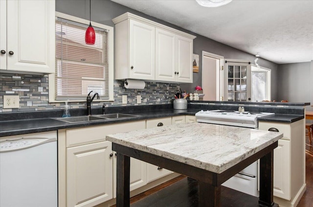 kitchen with sink, decorative light fixtures, white cabinets, white appliances, and backsplash