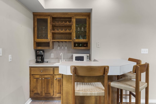 bar featuring light tile patterned floors and sink