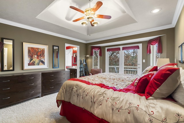 carpeted bedroom featuring ceiling fan, crown molding, access to outside, and a tray ceiling