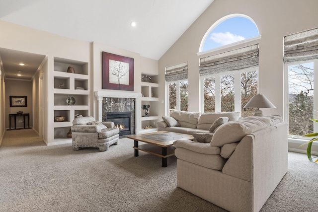 carpeted living room with built in features, high vaulted ceiling, and plenty of natural light