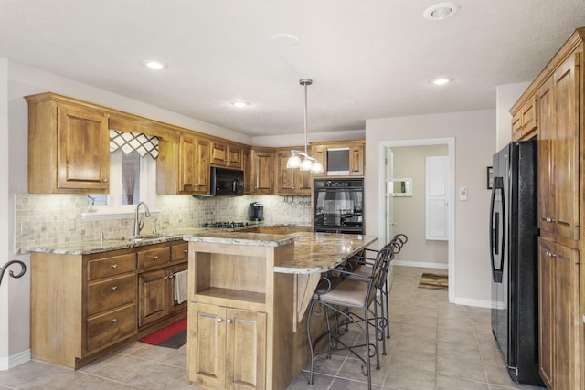 kitchen with a center island, sink, decorative light fixtures, decorative backsplash, and black appliances