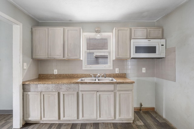 kitchen with tasteful backsplash, sink, and dark wood-type flooring