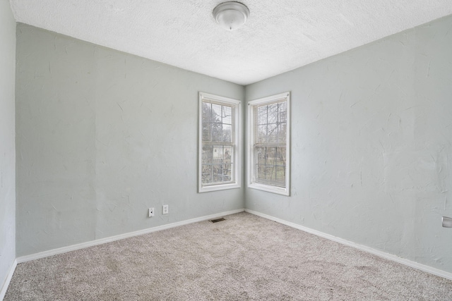 spare room featuring carpet floors and a textured ceiling