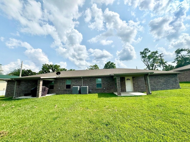 rear view of house with a yard, a patio, and central air condition unit