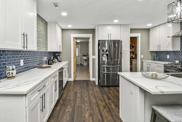 kitchen featuring white cabinets, dark hardwood / wood-style flooring, hanging light fixtures, and appliances with stainless steel finishes