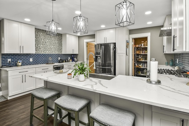 kitchen featuring white cabinetry, stainless steel appliances, and decorative light fixtures