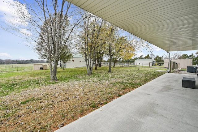 view of yard featuring a patio area, an outdoor structure, and central AC