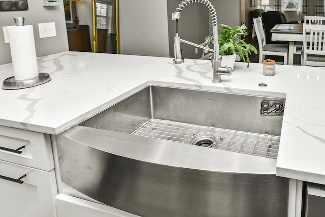 interior details with light stone countertops and sink