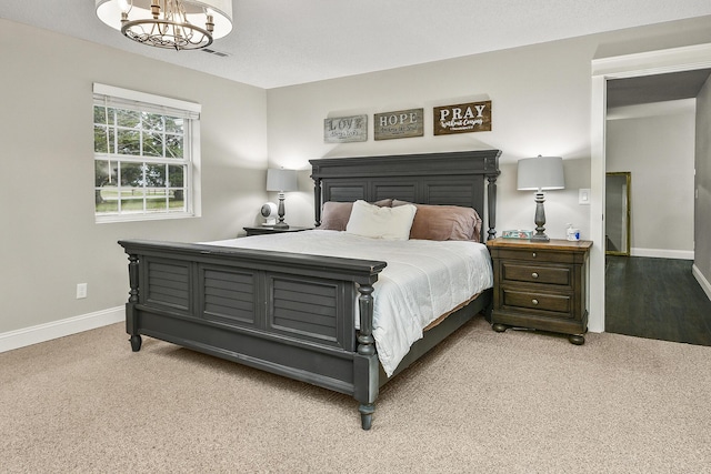 carpeted bedroom with an inviting chandelier