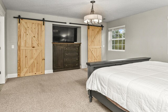 2314 State Highway 38, Elkland, MO 65644 - bedroom featuring a barn door, carpet floors, and a textured ceiling