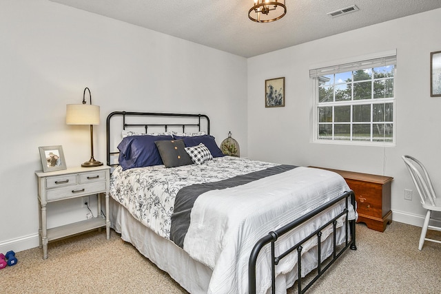 bedroom featuring light carpet and a textured ceiling