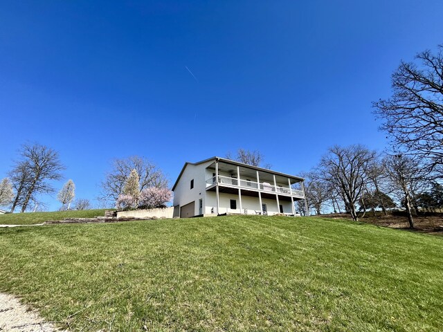 rear view of property featuring a yard and an attached garage