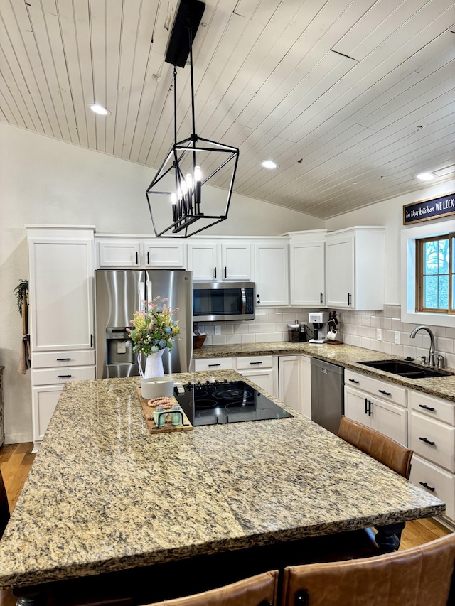 kitchen featuring a sink, tasteful backsplash, appliances with stainless steel finishes, and vaulted ceiling