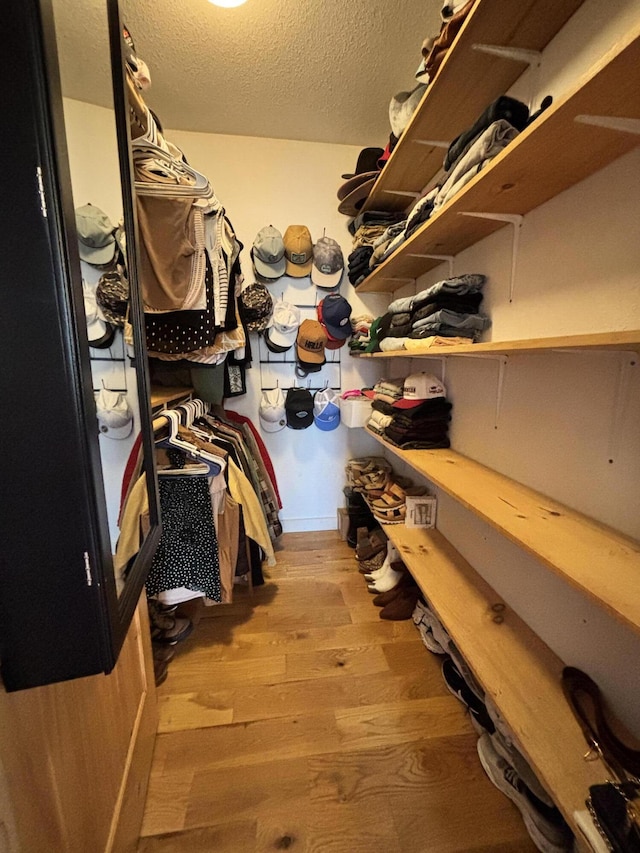 walk in closet with wood finished floors