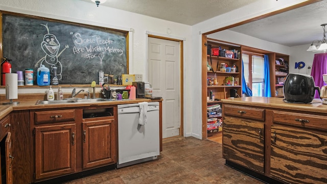 kitchen with sink, hanging light fixtures, white dishwasher, a chandelier, and a textured ceiling