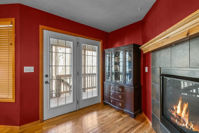 entryway featuring a fireplace, a textured ceiling, and light wood-type flooring