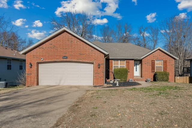 ranch-style house featuring a garage and cooling unit