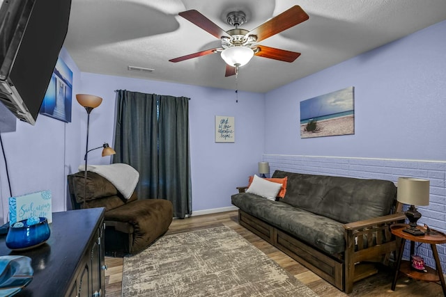 living room featuring ceiling fan, dark hardwood / wood-style flooring, and a textured ceiling