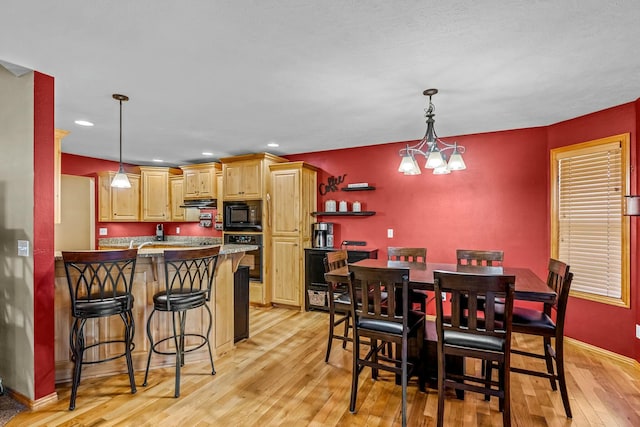 dining space featuring an inviting chandelier and light hardwood / wood-style flooring