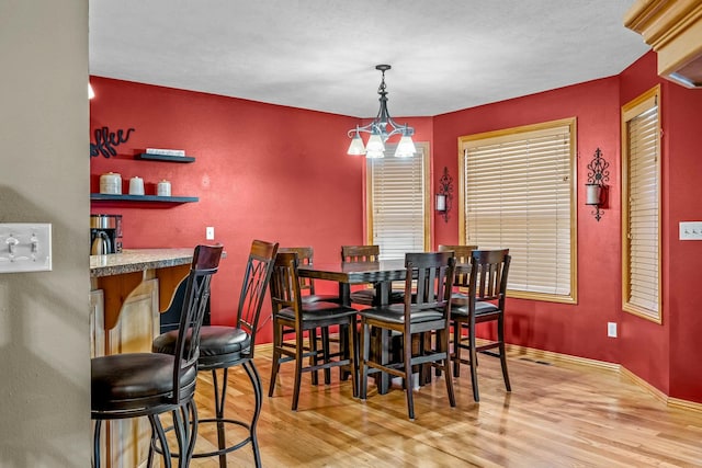 dining area featuring hardwood / wood-style floors and a notable chandelier