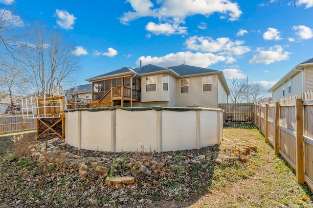 back of house featuring a fenced in pool and a sunroom