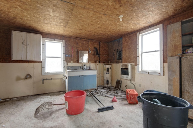 miscellaneous room with heating unit, a wealth of natural light, and water heater