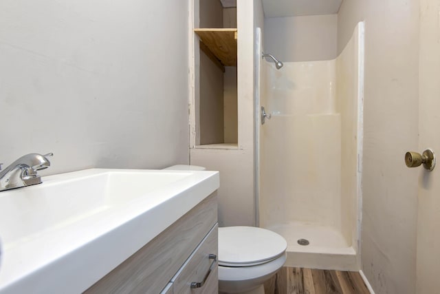 bathroom featuring vanity, hardwood / wood-style flooring, toilet, and walk in shower