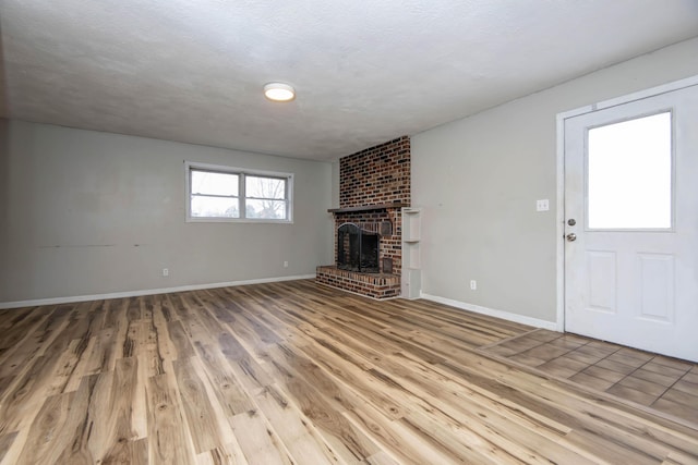 unfurnished living room with a fireplace, hardwood / wood-style floors, and a textured ceiling