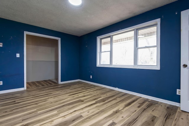 unfurnished bedroom with hardwood / wood-style flooring and a textured ceiling