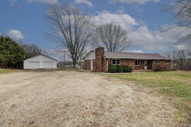 view of front facade featuring an outbuilding, a front lawn, and a garage