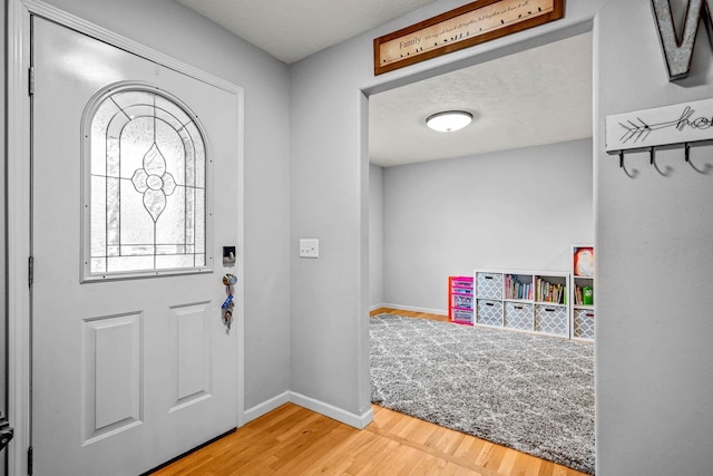 entryway with wood-type flooring and a textured ceiling