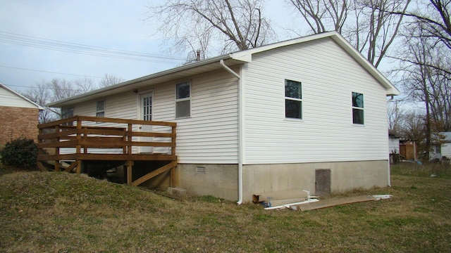 view of side of property featuring a yard and a wooden deck