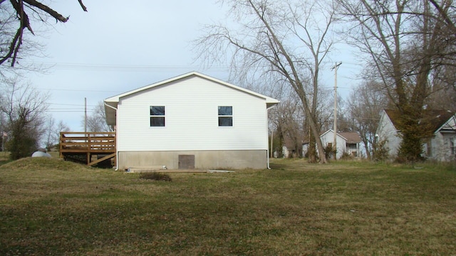 view of property exterior with a yard and a wooden deck