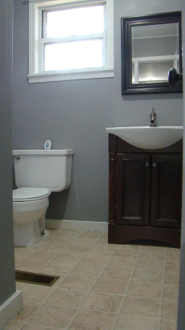 bathroom featuring tile patterned flooring, vanity, and toilet