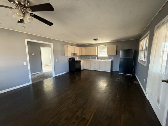 kitchen with black range with electric stovetop, plenty of natural light, dark hardwood / wood-style floors, and fridge