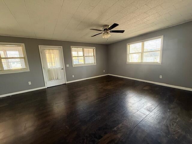 unfurnished room with ceiling fan and dark wood-type flooring