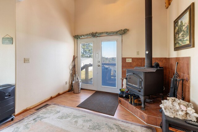 doorway to outside featuring wood-type flooring, a wood stove, and french doors