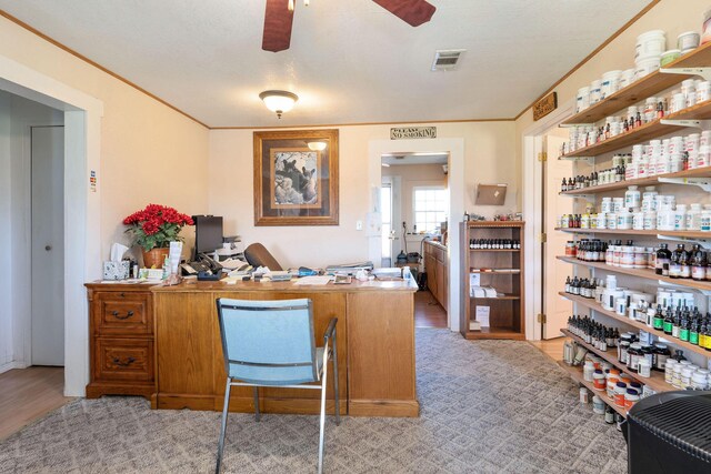 office featuring light hardwood / wood-style floors, ceiling fan, and crown molding