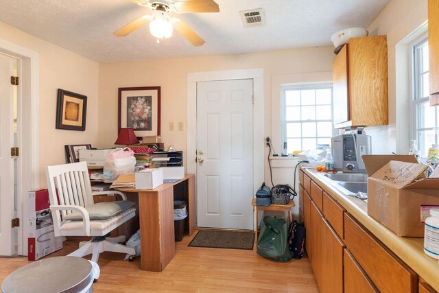 office space featuring ceiling fan, a textured ceiling, and light wood-type flooring