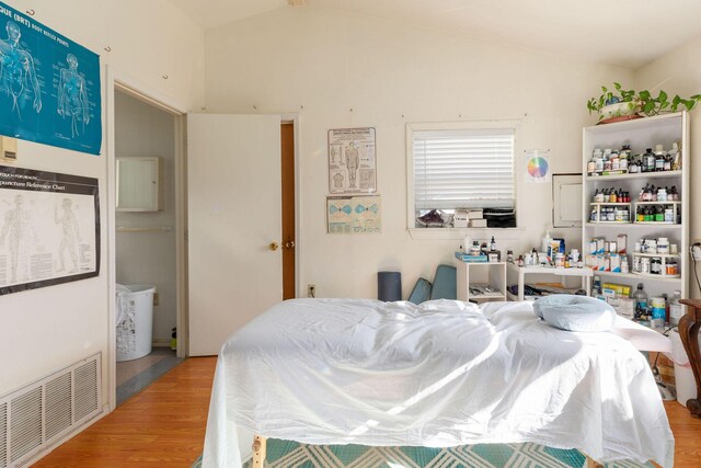 bedroom featuring light hardwood / wood-style flooring and lofted ceiling