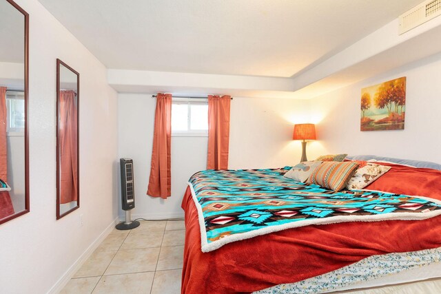 bedroom with light tile patterned flooring and heating unit