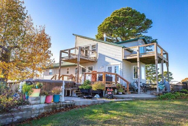 rear view of house featuring a lawn, a patio area, a balcony, and a deck