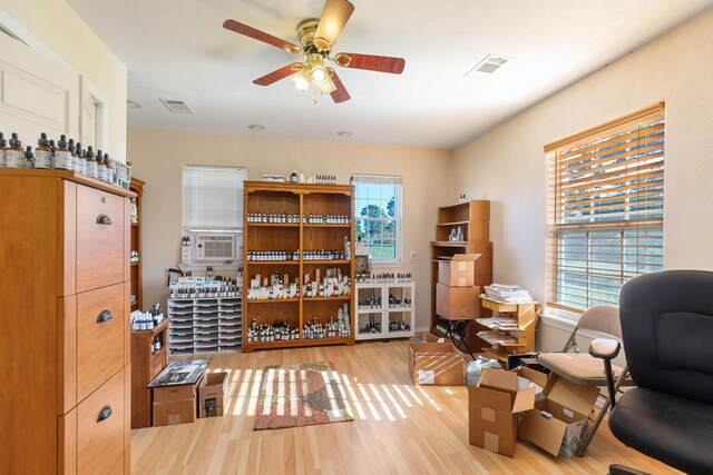 sitting room featuring light hardwood / wood-style floors, a wealth of natural light, cooling unit, and ceiling fan