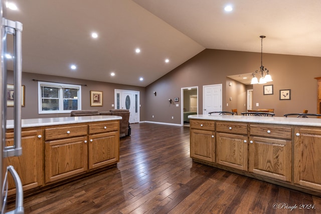 kitchen with dark wood-type flooring, high vaulted ceiling, an inviting chandelier, stainless steel refrigerator, and hanging light fixtures