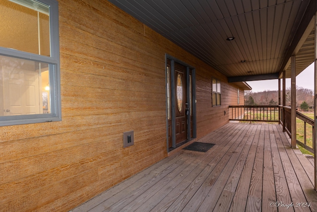 deck at dusk featuring a porch