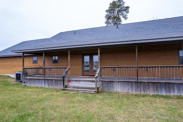 rear view of property with a lawn and cooling unit